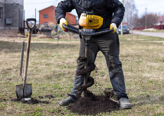 Worker digs the ground with a gasoline blower in the garden