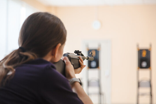 The girl shoots from a gun at a target.