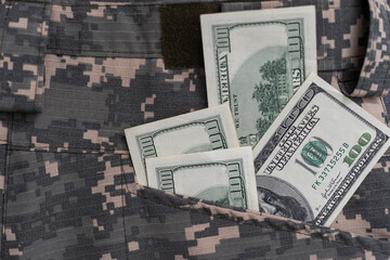 US dollar bills on fabric with texture of Ukrainian military pixeled camouflage. Cloth with camo...