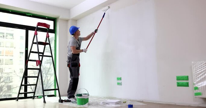Painting walls with white paint roller. Painting bare wall with roller with white paint