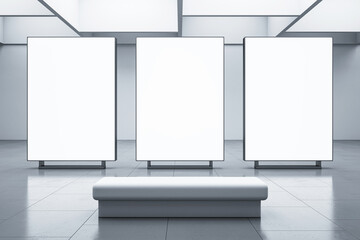 Front view on three blank white glowing screens with space for your advertising grey wall background opposite bench in abstract presentation hall interior. 3D rendering, mockup
