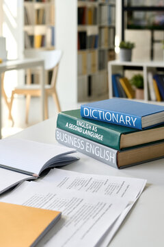 Vertical image of books and textbooks on the table in class for studying foreign language