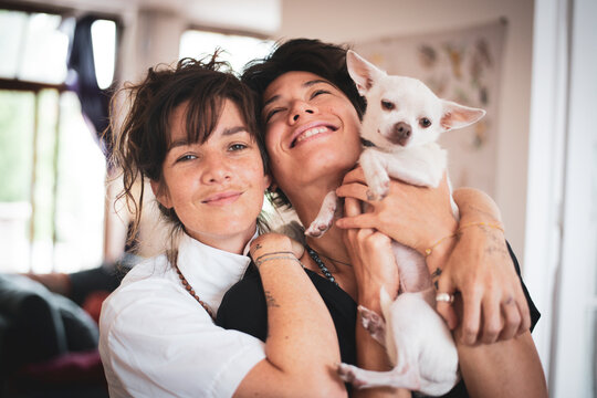 Joyful queer interracial family moment of couple with dog at home - Powered by Adobe