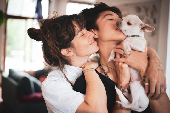 affectionate portrait of queer interracial family couple with dog