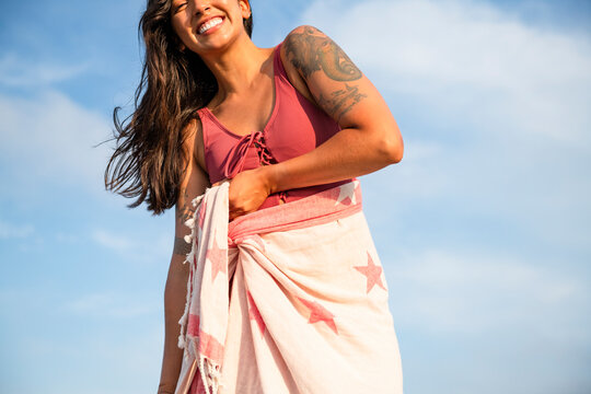 Latina woman having fun at the beach with towel wrap