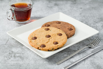 Chocolate chip cookies with tea on the stone table