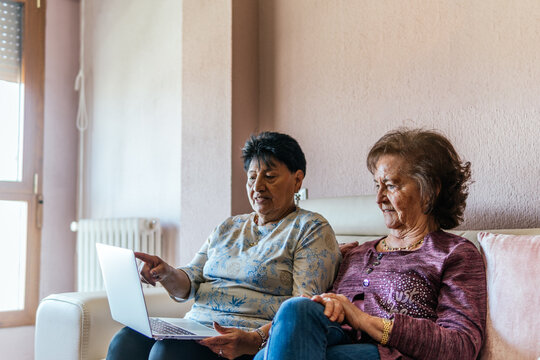 two elderly women watching a movie on the laptop