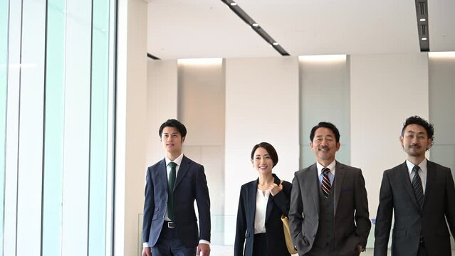 Video of a cool Japanese (Asian) businessman team dashing around in suits, full body copy space available