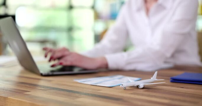 Agent typing on laptop keyboard near toy plane and flight tickets closeup 4k movie. Air travel concept