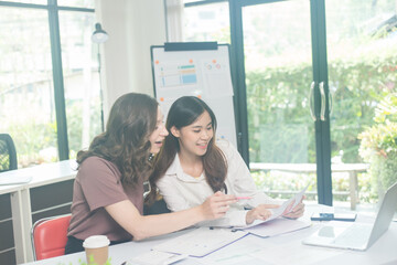 Two brunette business woman, talking, advising each other.