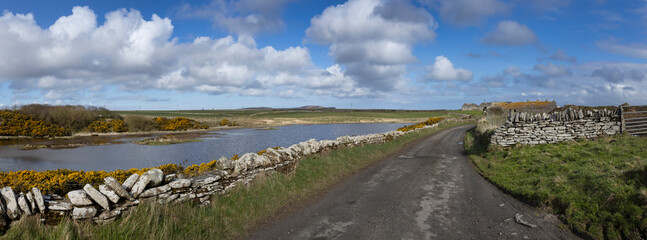 Canis Bay. Flagstones. Northern Scotland. Fagstone walls in landscape. Country road. Road. Panorama. Clouds.