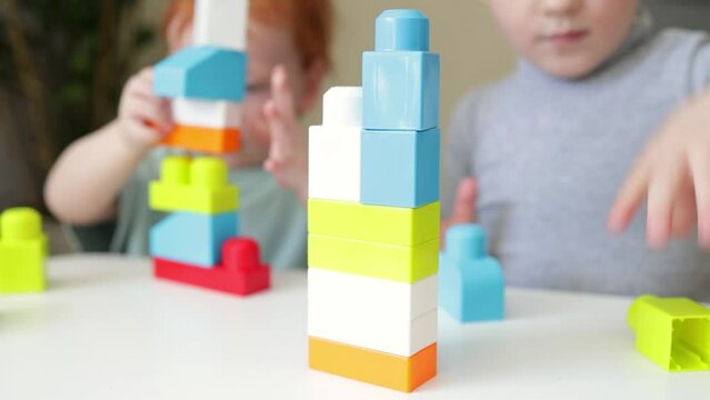 Close-up of a children's constructor. Children play on the table in the designer. The development of fine motor skills.