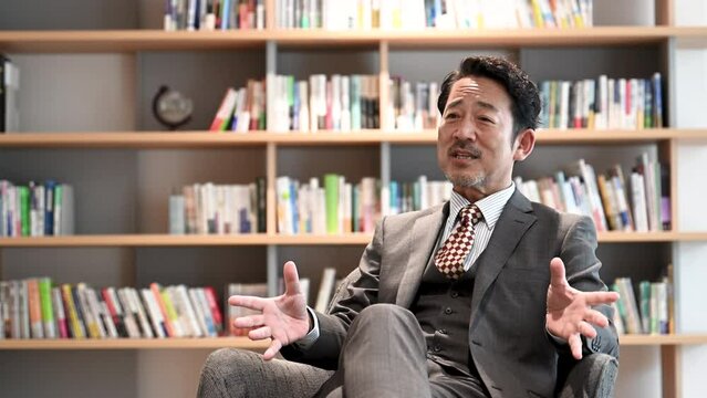 椅子に座ってインタビューなどで話すカッコイイ社長のイメージの動画