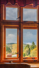 View through the window of the dining room in the PTTK Klimczok mountain tourist hostel on the Siodło Pass and Klimczok peak in the Silesian Beskids (Poland) on a sunny autumn day.