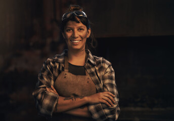 Woman blacksmith, portrait and smile in workshop, industrial warehouse or trade with...