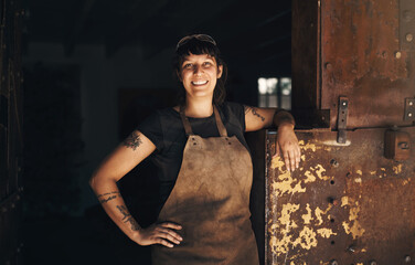 Woman blacksmith, portrait and smile in factory, industry and trade for entrepreneurship at artisan...