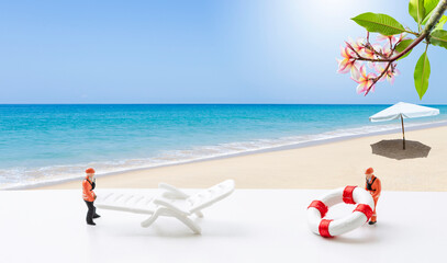 Miniature worker moving beach chair and life preserver over tropical beach background, summer...