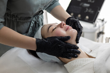 Woman enjoying a relaxing experience at a beauty salon is treated to a professional gel peeling...