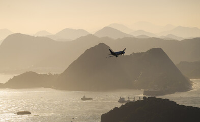 Airplane preparing to land on the Santos Dumont airport from Rio de Janeiro. Aerial photo with plane and the silhouettes of this mountain landscape in Brazil.
