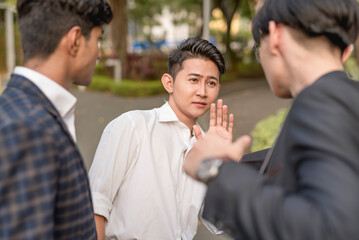 Two men bully and physically threatens their fearful workmate while cornering him at the park....