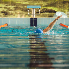 Woman swimming with swimming hat in swimming pool