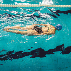 Woman swimming with swimming hat in swimming pool