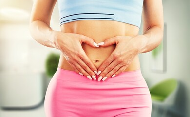 A young woman with hands to her stomach