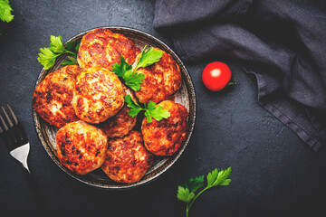 Homemade fried pork and beef meatballs in ceramic bowl, dark table background, top view