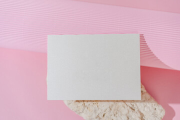 White glitter wedding invitation card mockup on pink background top view. Folded woman business card mock up. Name card, place card, birthday folded card mockup