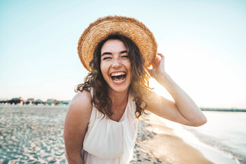Happy beautiful young woman smiling at the beach side - Delightful girl enjoying sunny day out -...