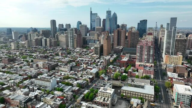 Aerial orbit of Philadelphia skyline from South Philly. USA mega city on beautiful spring day. Drone establishing shot of skyscrapers and houses.