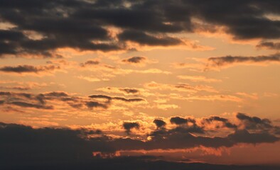 Sunrise with dark clouds against a reddish sky