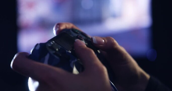 Hands, controller and gaming with a person playing an online video game for fun or leisure in a dark room. Esports, streaming and entertainment with a gamer or streamer holding a remote control