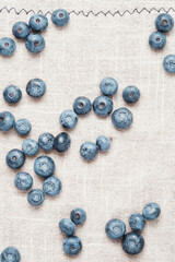 Fresh blueberries scattered on a linen napkin.
