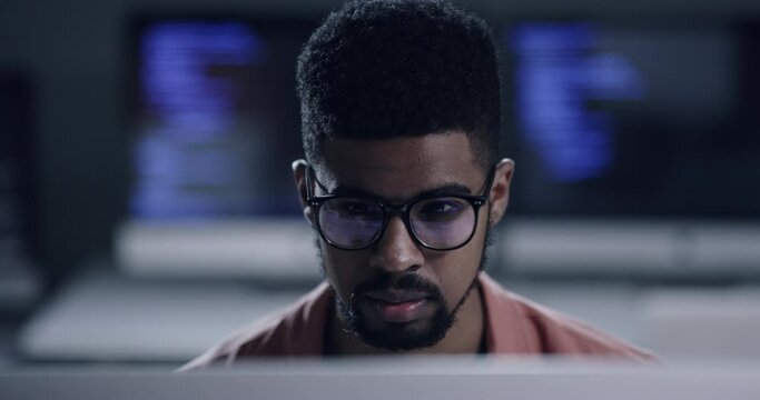 Face, glasses and programming with a black man coder working in a dark office for data processing. Focus, software development or programming with a male coder reading computer language on a database