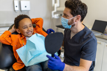 Dark-skinned boy talking to dentist before session