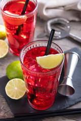 Cape Codder cocktail with vodka, cranberry juice and lime on wooden table