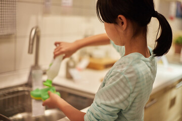 家のキッチンでお皿を洗う子供 - obrazy, fototapety, plakaty