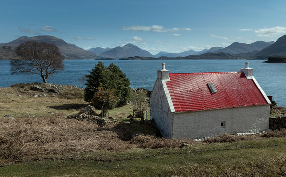 Loch Claira Scottish Highlands. Scotland. Lake.  Little white cottage with red roof. Mountains.