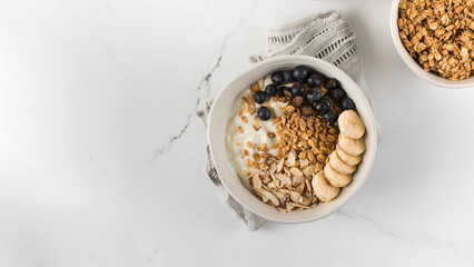 Homemade granola with Greek yogurt, almonds, blueberries and banana in a bowl. Copy space - Powered by Adobe