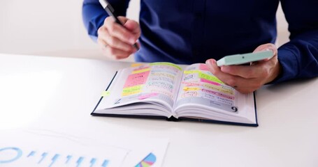 Businessman Holding Cellphone And Calendar Writing Schedule