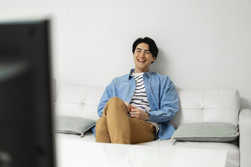 ソファに座ってテレビを見ている日本人