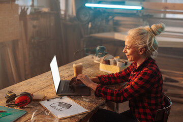 Workshop business owner using laptop at work.