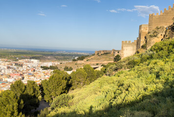 Obraz premium View of Sagunto Castle. Ruins walls of the Fortress Castle at the town of Sagunto, near Valencia in Spain. Fortress Castillo in Mountains hills. Fort on mountain.