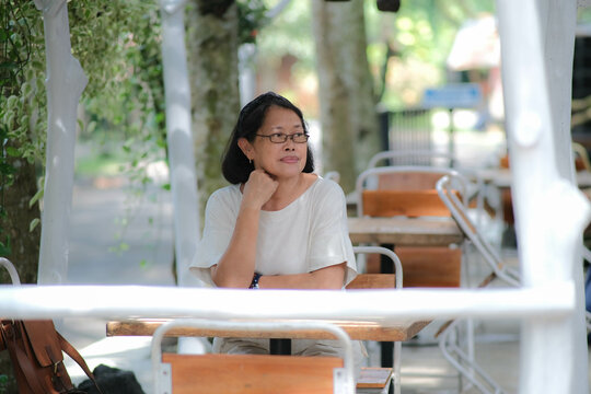 A middle-aged woman sitting alone in a cafe
