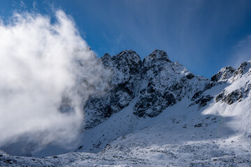 Fototapeta na wymiar Panorama of Mountaineer standing on top of snowy mountain range at High Tatras, Slovakia