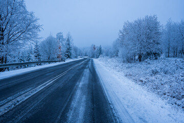 Fototapeta na wymiar Country road in snowy winter day