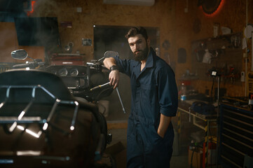 Obraz na płótnie Canvas Handsome brutal repairman in work wear looking at camera portrait