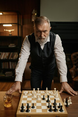 Portrait of serious senior man chess player over chessboard with game piece