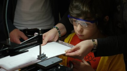 Young student acquiring woodworking skills with the guidance of an instructor, using a dedicated cutting machine and wearing protective eyewear. Role of Mentorship in Children's Woodworking Workshops